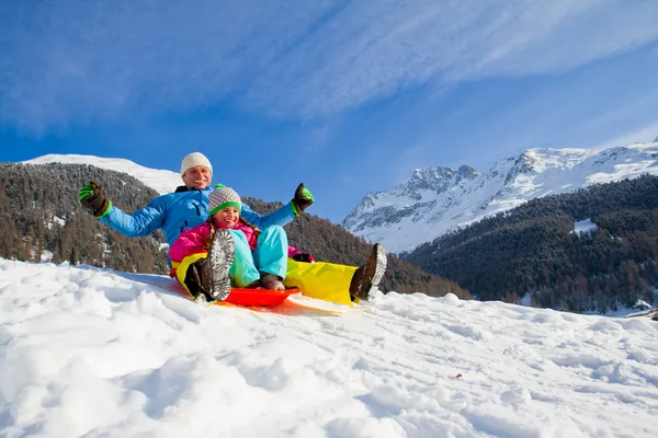 冬天好玩，下雪了，在冬天的时候滑雪橇的家庭 — 图库照片