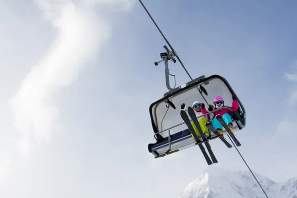 Ski lift, skiing, ski resort - happy skiers on ski lift