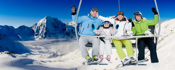 Ski lift, skiing, ski resort - happy skiers on ski lift — Stock Photo, Image