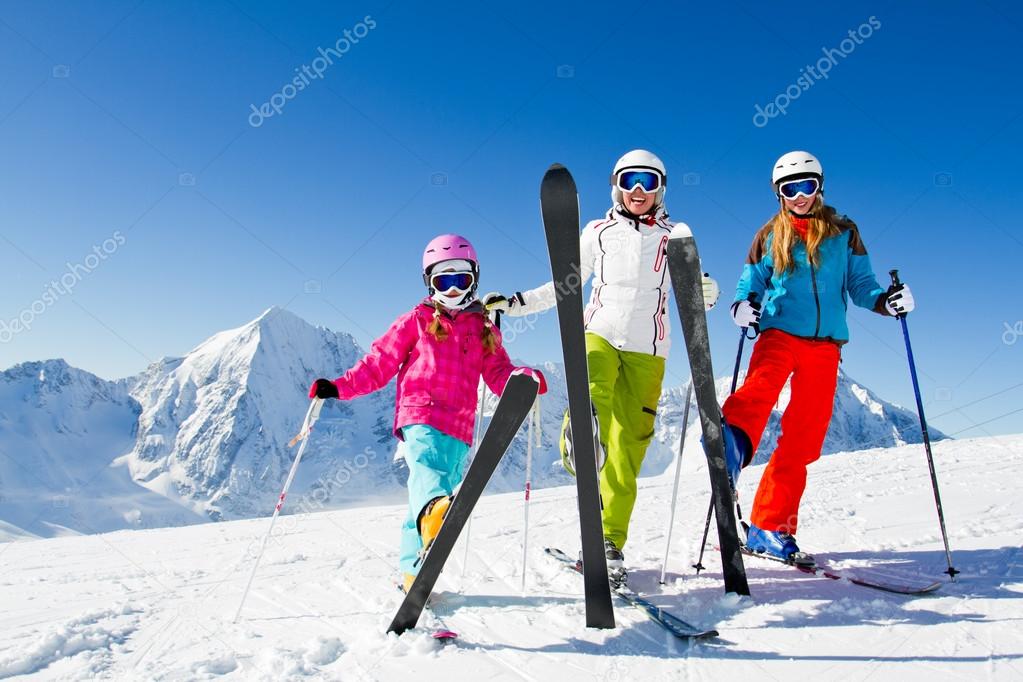 Skiing, winter fun - happy skiers on ski holiday