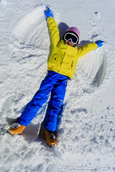 Zimní zábava - sníh anděl - mladý lyžař dívka hraje ve sněhu — Stock fotografie