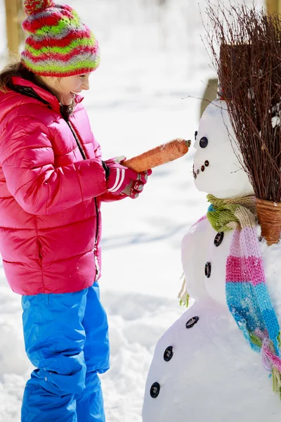 Téli szórakozás, boldog gyerek játszik a hóember — Stock Fotó