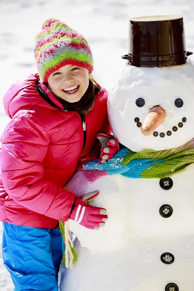 Diversión de invierno, niño feliz jugando con muñeco de nieve — Foto de Stock