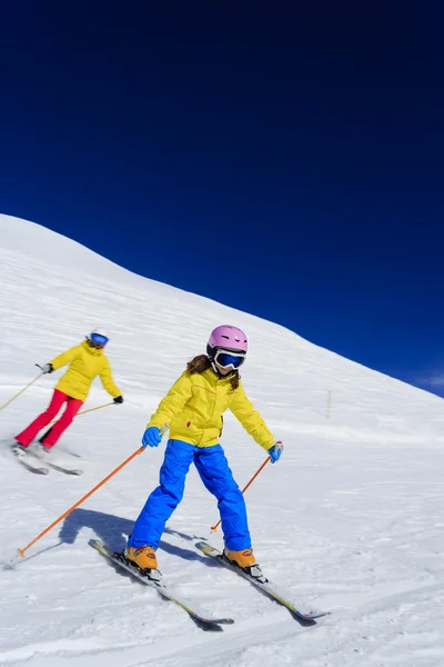 Skiing, skiers on ski run - child skiing downhill, ski lesson Royalty Free Stock Photos