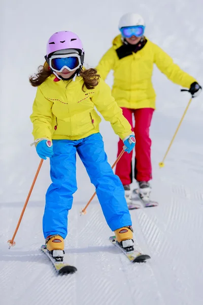 Skiing, skiers on ski run - child skiing downhill, ski lesson Stock Picture