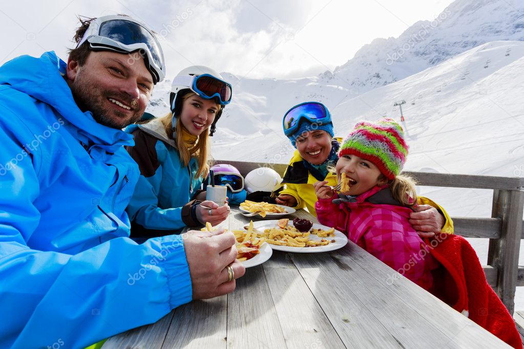 Winter, ski - skiers enjoying lunch in winter mountains