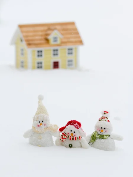 Winter, happy snowman friends in background wooden house — Stock Photo, Image