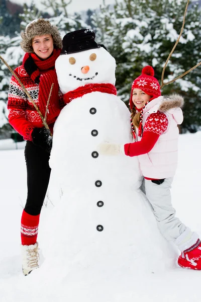 Winter fun, snowman and happy family — Stock Photo, Image