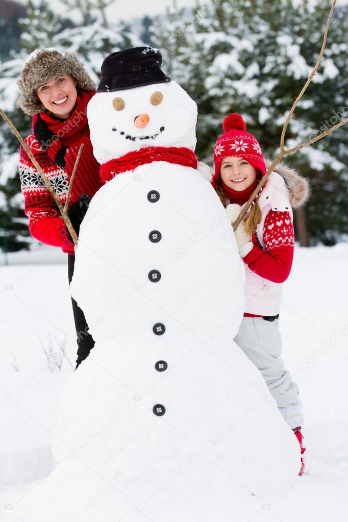 Winter fun, snowman and happy family