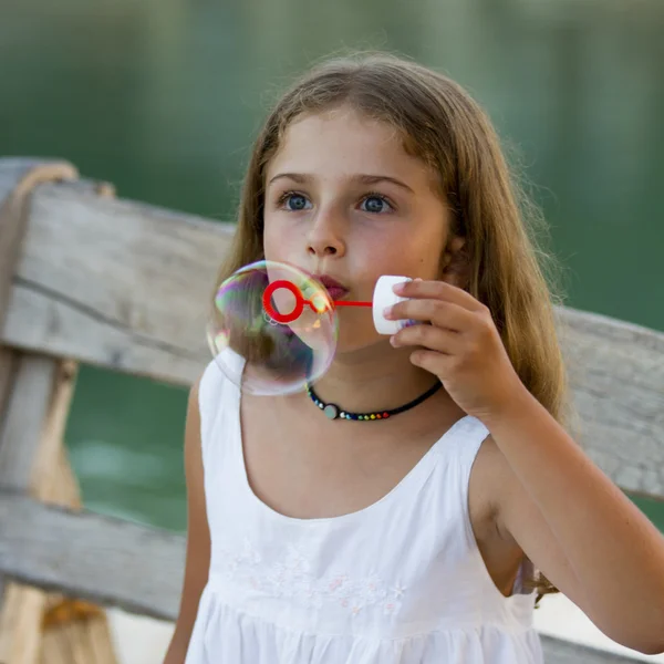 Alegria de verão, bolhas de sabão - linda menina soprando bolhas — Fotografia de Stock