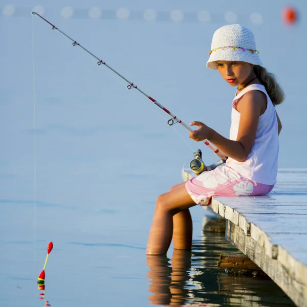 Fishing - lovely girl fishing on the pier — Stock Photo, Image