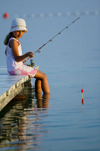 Fishing - lovely girl fishing on the pier — Stock Photo, Image