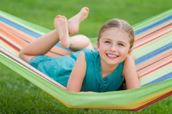 Estate, riposo in giardino - bella ragazza in amaca colorata — Foto Stock