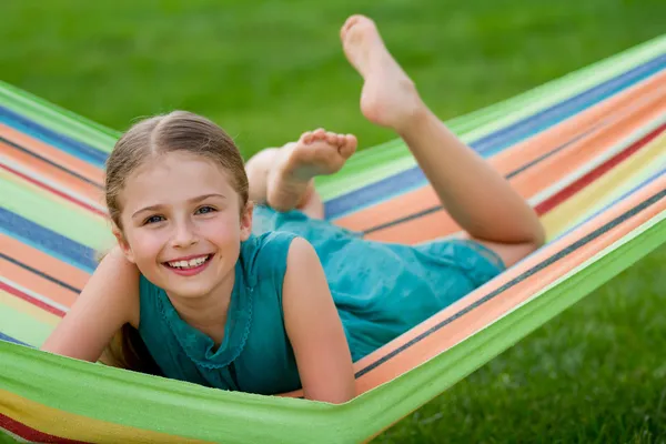 Zomer, rust in de tuin - mooi meisje in kleurrijke hangmat — Stockfoto