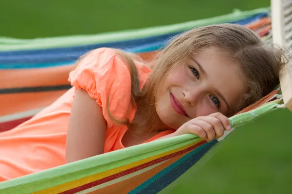 Estate, riposo in giardino - bella ragazza in amaca colorata — Foto Stock