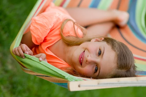 Estate, riposo in giardino - bella ragazza in amaca colorata — Foto Stock