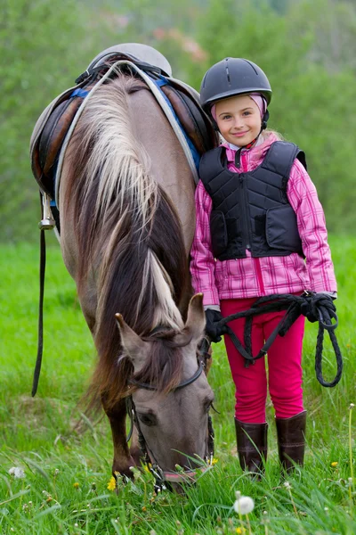 Caballo y jinete - niña pequeña está pastando el caballo en el prado — Foto de Stock