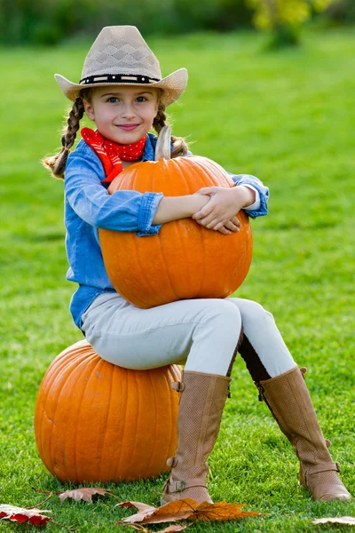La cosecha de las calabazas, el otoño en el jardín - la muchacha encantadora y las calabazas grandes —  Fotos de Stock