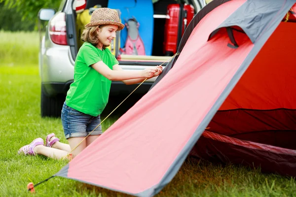 Camper sous la tente - une jeune fille installe une tente sur le camping — Photo
