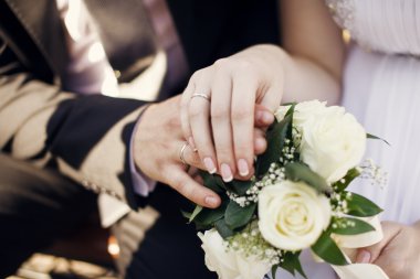 Yeni evli bir çift koyun elleri üzerinde düğün buketi