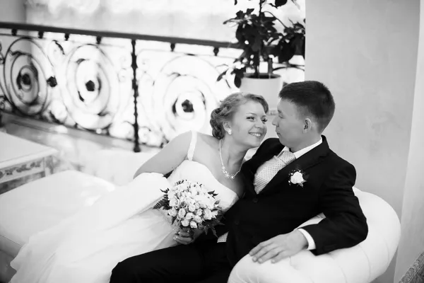 Wedding couple hugging, bride and groom on a sofa — Stock Photo, Image