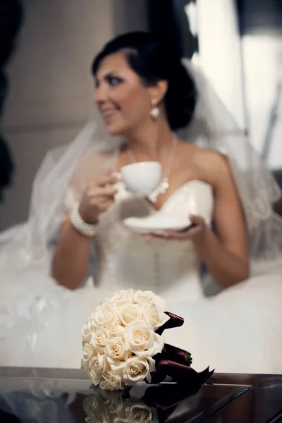 Mooi boeket en mooie bruid op de achtergrond — Stockfoto