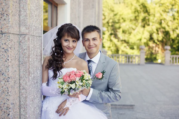 Recém-casados estão perto da parede — Fotografia de Stock