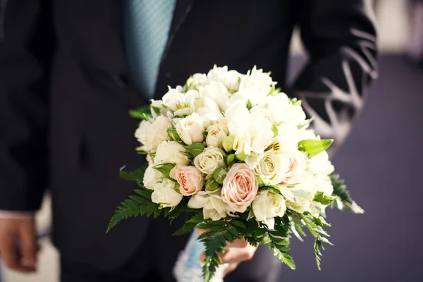 Un jeune marié tenant un bouquet de fleurs — Photo