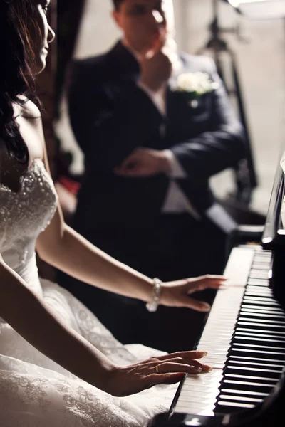 Newlyweds. Bride playing piano Stock Image