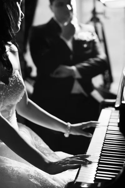 Newlyweds. Bride playing piano Stock Photo