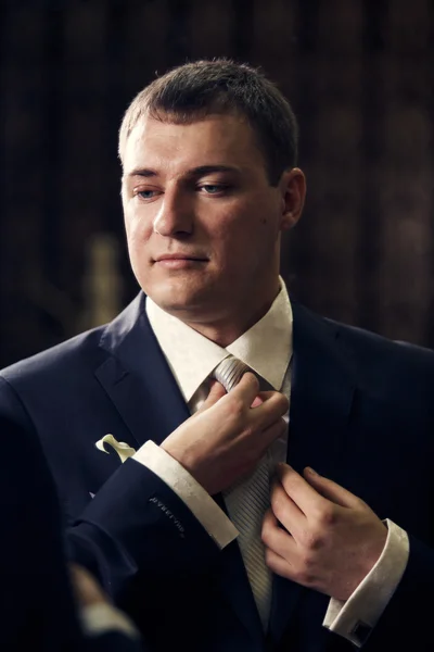 Portrait of a groom adjusting his tie — Stock Photo, Image