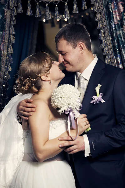 Noiva e noivo no fundo de velhas cortinas — Fotografia de Stock