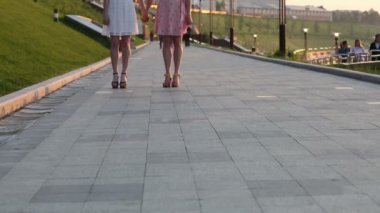 atlama ve el ele tutuşarak iki kız closeup. Bacaklarını göster