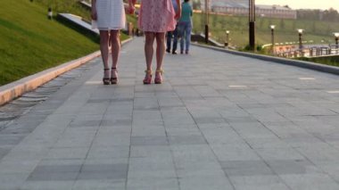 atlama ve el ele tutuşarak iki kız closeup. Bacaklarını göster