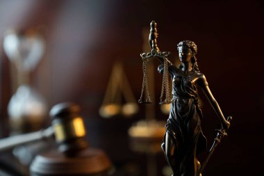 Avukatlık bürosu. Hukuk sembolleri: Hakimler tokmak, Themis heykeli ve ölçek.