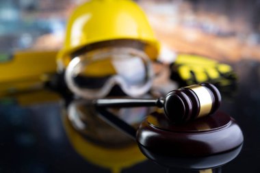 İş hukuku ve gelişen hukuk kavramı. Gavel ve sarı kask parlayan lağım masasında..