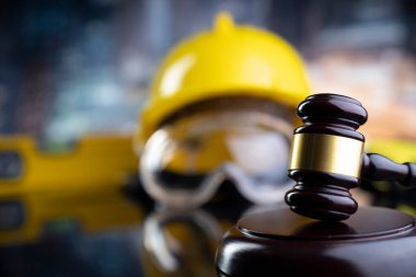 İş hukuku ve gelişen hukuk kavramı. Gavel ve sarı kask parlayan lağım masasında..