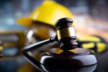 İş hukuku ve gelişen hukuk kavramı. Gavel ve sarı kask parlayan lağım masasında..