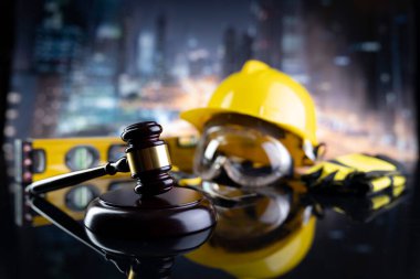 İş hukuku ve gelişen hukuk kavramı. Gavel ve sarı kask parlayan lağım masasında..