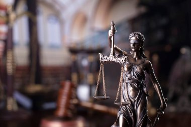 Hukuk teması. Mahkeme kütüphanesi - hakimin tokmağı, heykel, ölçü ve kitaplar.