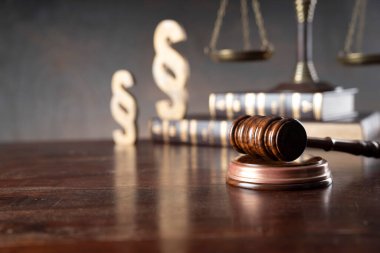 Avukatlık bürosu. Hukuk sembolleri: Hakimler tokmak, heykel, paragraf işareti ve ölçek.