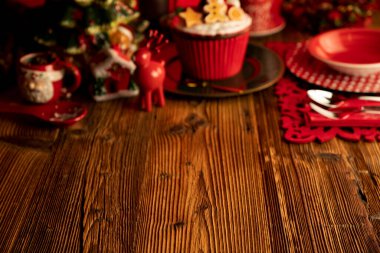 Noel arkaplanı. Kırsal ahşap masada Noel sofra takımı ve süslemeleri.