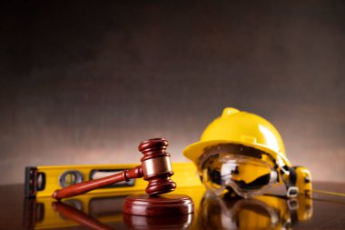 İş hukuku ve gelişen hukuk kavramı. Gavel ve sarı kask parlayan avukat masasında..