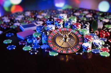 Kumarhane teması. Renkli arkaplanda rulet çarkı ve poker çipleri.