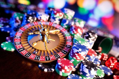 Kumarhane teması. Renkli arkaplanda rulet çarkı ve poker çipleri.