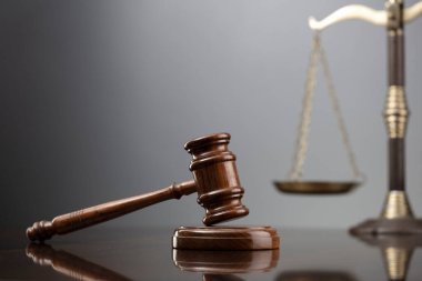 Hukuk sembolleri kompozisyonu. Hukuk ve adalet kavramı. Gri arkaplanda Gavel ve skalası.