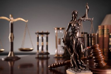 Yargıç ofisi. Gavel, terazi, heykel, kum saati ve hukuk kitapları masanın üstünde..