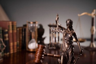Yargıç ofisi. Gavel, terazi, heykel, kum saati ve hukuk kitapları masanın üstünde..
