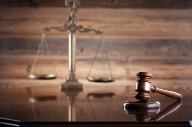 Hukuk kavramı. Hukuk sembolleri kompozisyonu: Hakimler tokmak, Themis heykeli ve kahverengi arkaplan ölçeği.