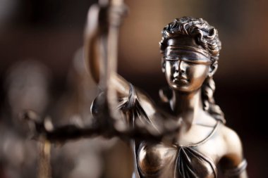 Yargıç ofisi. Adalet sembolü - Kahverengi arkaplanda heykel.